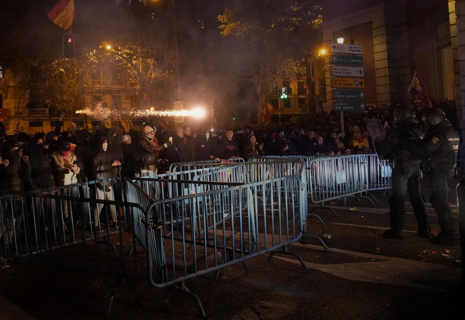 Demonstrators throw fireworks at police as they protest against the amnesty at the headquarters of Socialist party in Madrid, Spain, Thursday, Nov. 9, 2023. Acting Spanish Prime Minister Pedro Sánchez's chances of forming a new coalition minority government following an inconclusive election in July have been massively boosted by a deal with a tiny party he surely hoped he would never have to rely on. (AP Photo/Andrea Comas)