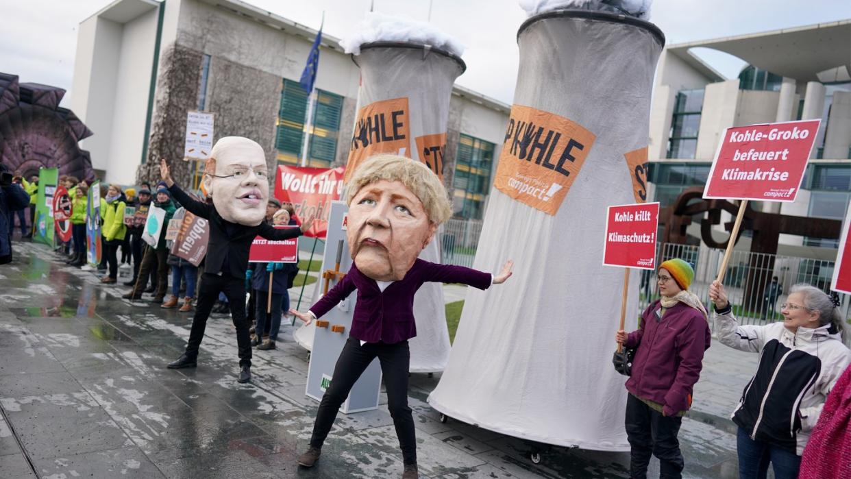 Aktivisten protestieren verkleidet als Angela Merkel und Peter Altmaier vor dem Bundeskanzleramt gegen den Zeitplan für den Kohleausstieg.