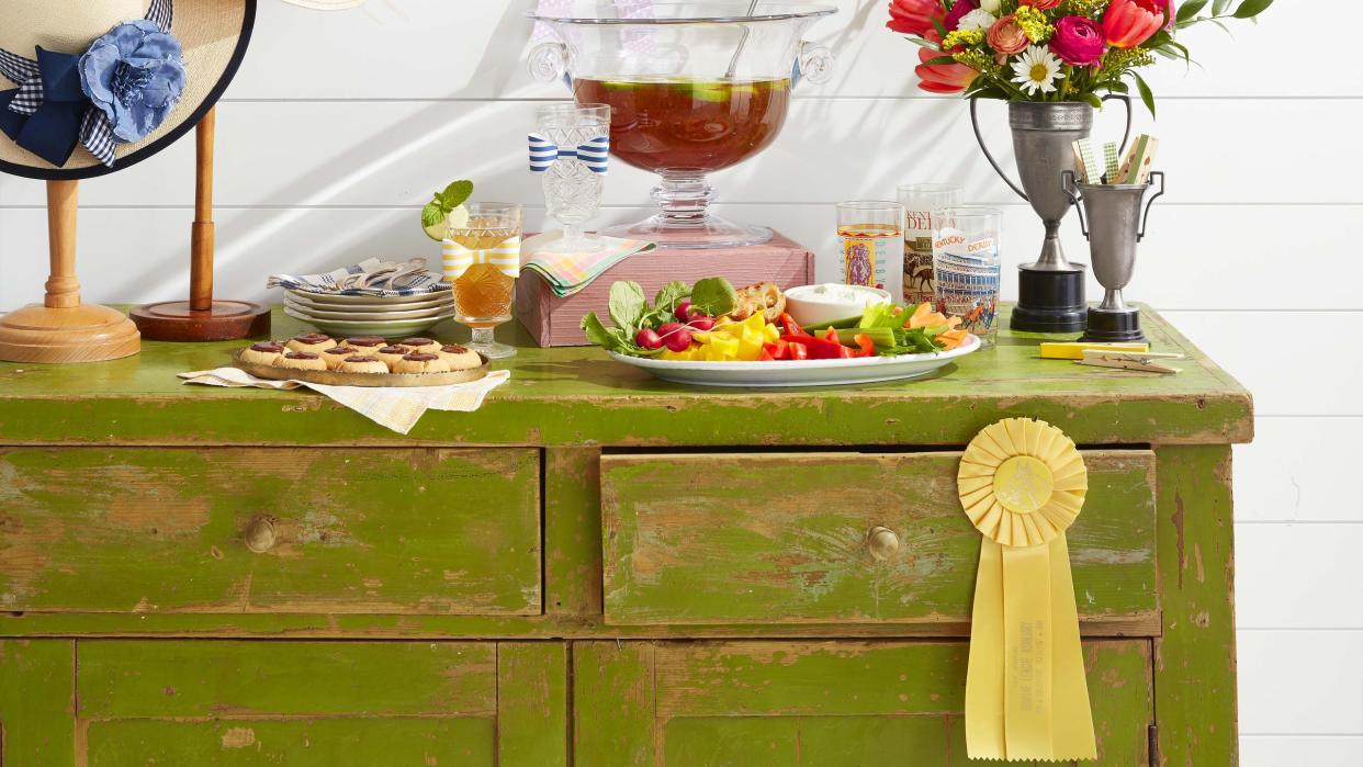 kentucky derby day party kentucky benedictine dip, betting ribbons, hats on vintage stands, horseshoe “wreath”, flowers in vintage trophy “vases”