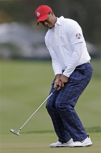 Tiger Woods reacts after missing a putt on the third hole. (AP)