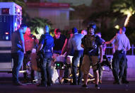 <p>Police officers stand by as medical personnel tend to a person on Tropicana Ave. near Las Vegas Boulevard after a mass shooting at a country music festival nearby on Oct. 2, 2017 in Las Vegas, Nevada. (Photo: Ethan Miller/Getty Images) </p>