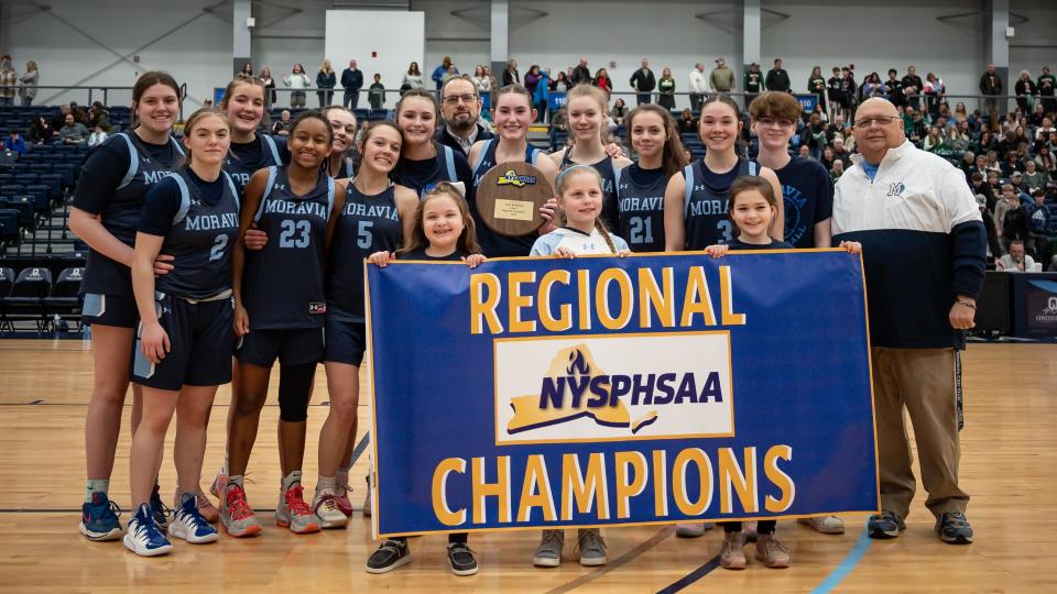Moravia players celebrate after defeating Hamilton 64-56 and securing the 2023-24 NYSPHSAA Girls Basketball Regional Championship inside SRC Arena at Onondaga Community College on Saturday, March 9, 2024.