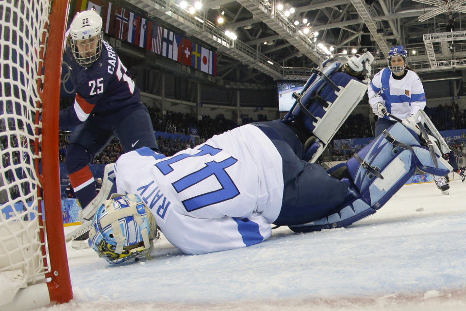 Goalkeeper Noora Raty of Finland falls on the puck to block a who by Alex Carpenter of the Untied States during the third period of the 2014 Winter Olympics women's ice hockey game at Shayba Arena, Saturday, Feb. 8, 2014, in Sochi, Russia. (AP Photo/Matt Slocum)