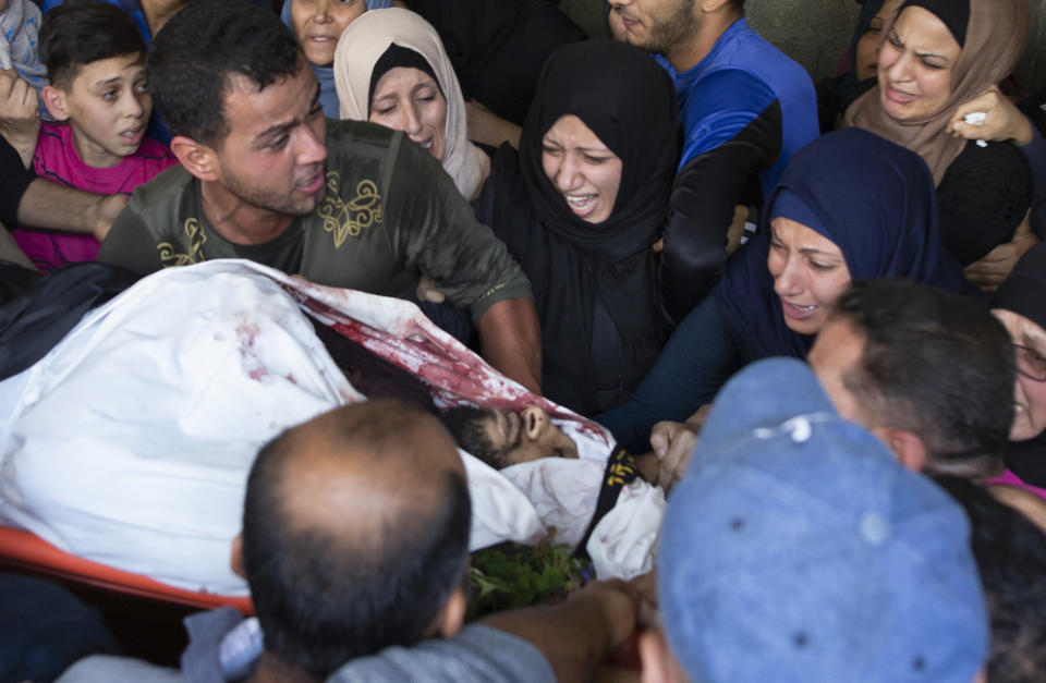 Relatives of Islamic Jihad militant, Abdullah Al-Belbesi, 26, who was killed in Israeli airstrikes, mourn over his body, in the family home during his funeral in the town of Beit Lahiya, Northern Gaza Strip, Wednesday, Nov. 13, 2019. Gaza's Health Ministry said Wednesday that more Palestinians have been killed by ongoing Israeli airstrikes, bringing the death toll in the escalation over the past two days to at least 18. (AP Photo/Khalil Hamra)