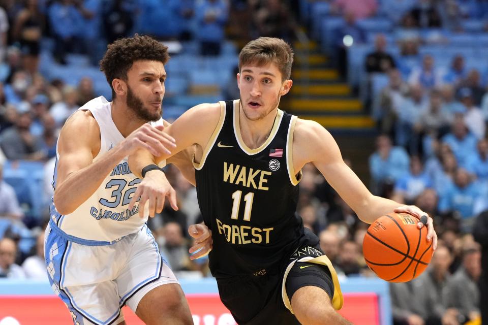 Jan 4, 2023; Chapel Hill, North Carolina, USA;  Wake Forest Demon Deacons forward Andrew Carr (11) dribbles as North Carolina Tar Heels forward Pete Nance (32) defends in the first half at Dean E. Smith Center. Mandatory Credit: Bob Donnan-USA TODAY Sports