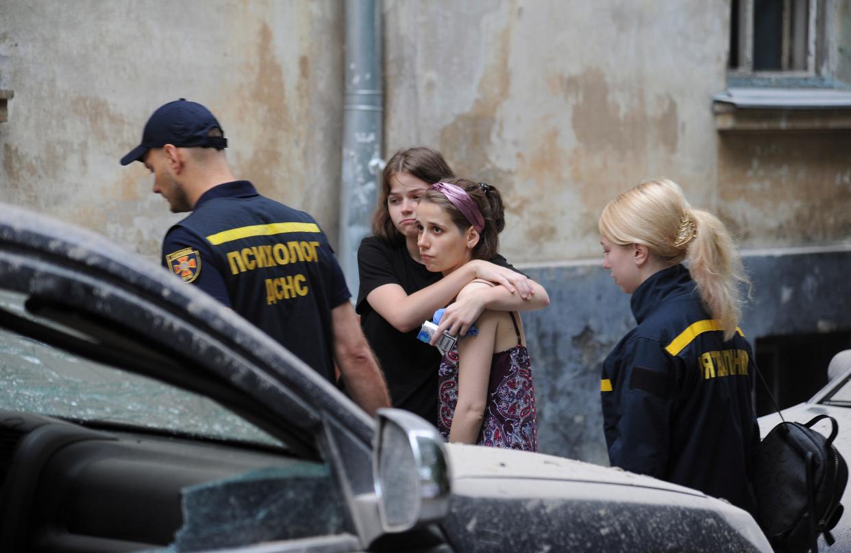 Locals react after an apartment block was damaged by a rocket in Lviv (EPA)