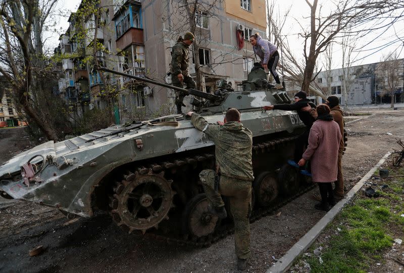 Foto de arcchivo de soldados prorrusos ayudando a civiles a subir a un tanque en Mariupol