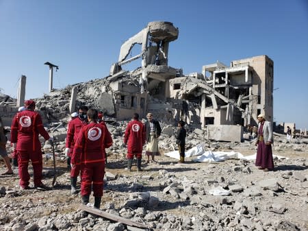 Red Crescent medics stand at the site of Saudi-led air strikes on a Houthi detention centre in Dhamar