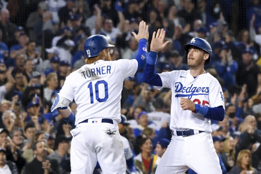 Los Angeles, CA - October 20: Los Angeles Dodgers' Cody Bellinger, right, celebrates with Justin Turner after a two-run single by AJ Pollock during the fifth inning in game four in the 2021 National League Championship Series against the Atlanta Braves at Dodger Stadium on Wednesday, Oct. 20, 2021 in Los Angeles, CA. (Wally Skalij / Los Angeles Times)