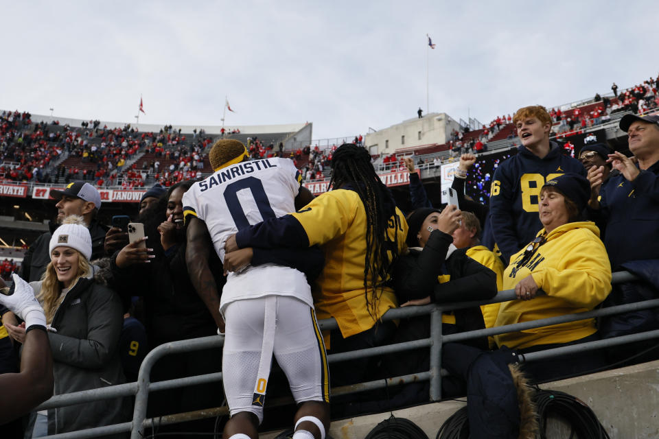 Michigan defensive back Mike Sainristil jumps into a section of fans after their win over Ohio State in an NCAA college football game on Saturday, Nov. 26, 2022, in Columbus, Ohio. (AP Photo/Jay LaPrete)