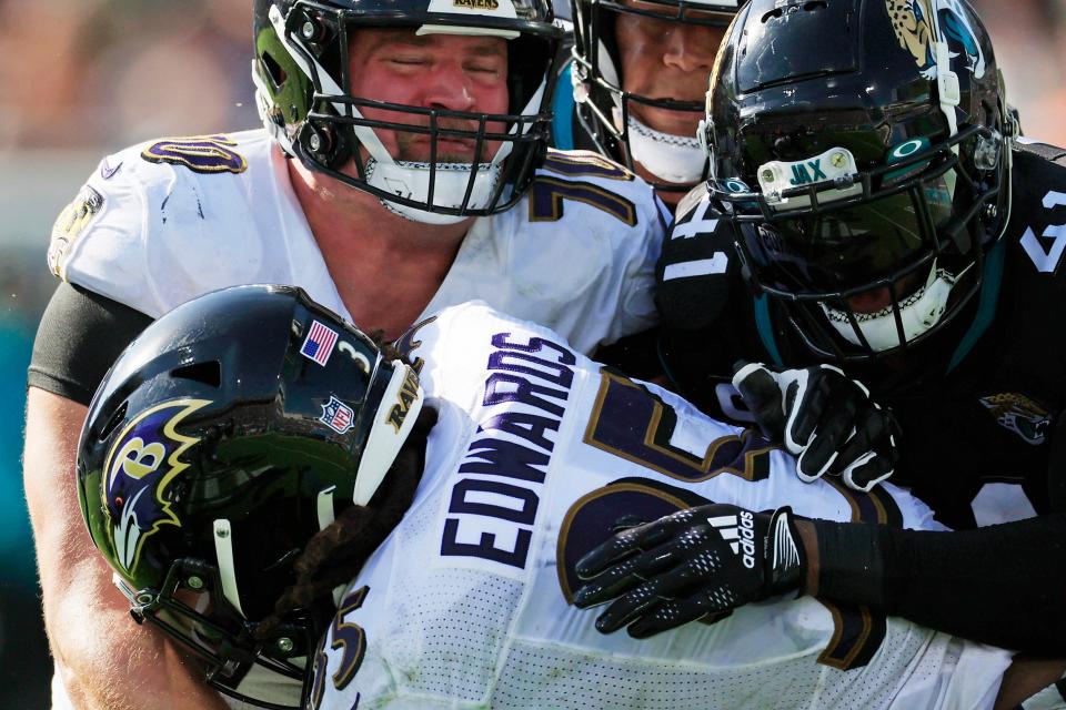 Kevin Zeitler (left, No. 70) blocks as running back Gus Edwards looks for more yards in a 2022 NFL game.