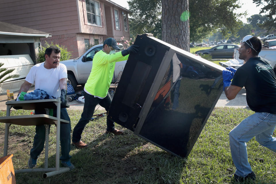 Volunteers from Performance Contractors help co-worker Cornell Beasley clear up the&nbsp;damage to his home.