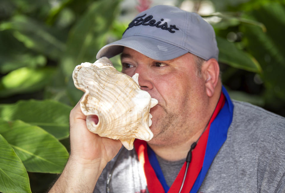 In this photo provided by the Florida Keys News Bureau, Brian Cardis demonstrates his prowess as he blows a conch shell following his men's division victory at the Conch Shell Blowing Contest, Saturday, March 4, 2023, in Key West, Fla. Organized by the Old Island Restoration Foundation, the event is a Key West tradition that began in 1972. The conch shell is a symbol of the Florida Keys. (Mary Martin/Florida Keys News Bureau via AP)
