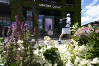 A man walks past the statue to former Wimbledon champion Fred Perry ahead of the Wimbledon tennis championships in London, Sunday, June 26, 2022. (AP Photo/Kirsty Wigglesworth)