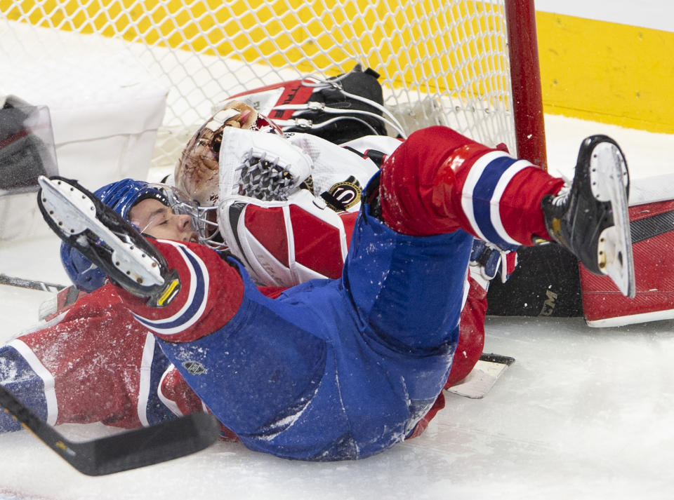 Montreal Canadiens center Jesperi Kotkaniemi (15) crashes against Ottawa Senators goaltender Joey Daccord (34) during the second period of an NHL hockey game Tuesday, March 2, 2021, in Montreal. (Ryan Remiorz/The Canadian Press via AP)