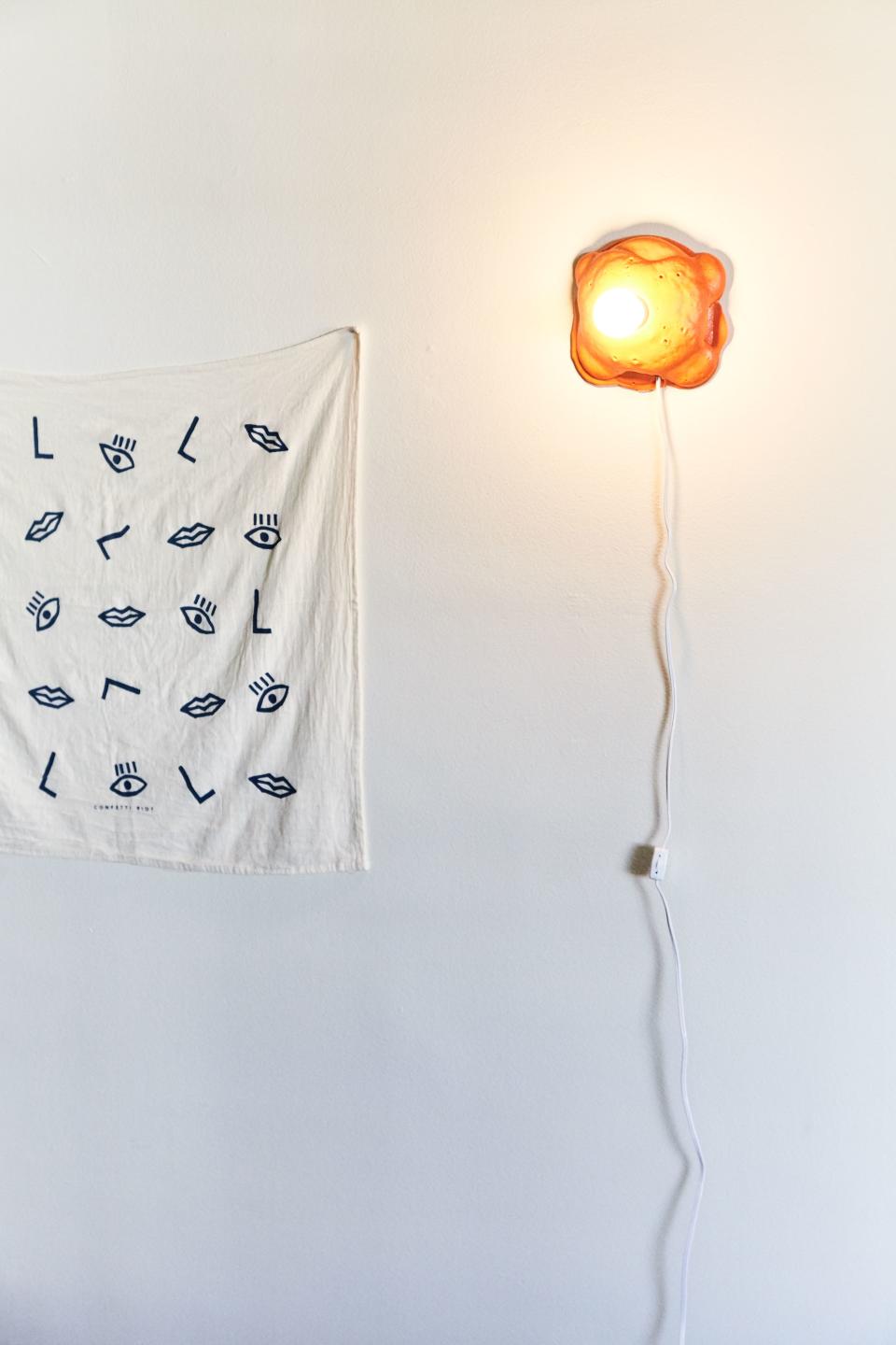 This tapestry is actually a tea towel Leah bought on Etsy years ago, and next to it is Joseph Algieri’s sconce for Clever x Urban Outfitters. “I snatched that up the day it went on sale. I'm obsessed with his work,” she says of the sconce.