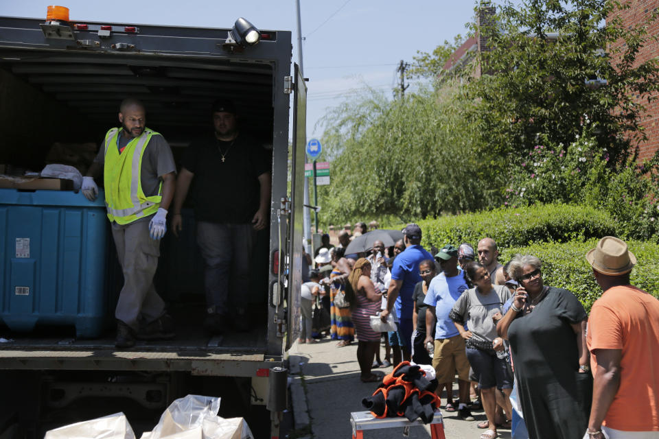 A Con Edison truck distributes dry ice to a line of people in a neighborhood without power in the Brooklyn borough of New York, Monday, July 22, 2019. Mayor Bill de Blasio called for an investigation Monday of power outages that came at the end of this weekend's oppressive heat, saying he no longer trusts utility Con Edison after it decided to turn off power to thousands of customers. (AP Photo/Seth Wenig)