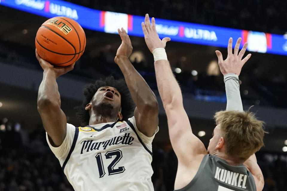 Marquette's Olivier-Maxence Prosper (12) shoots against Xavier's Adam Kunkel during the first half of an NCAA college basketball game Wednesday, Feb. 15, 2023, in Milwaukee. (AP Photo/Aaron Gash)