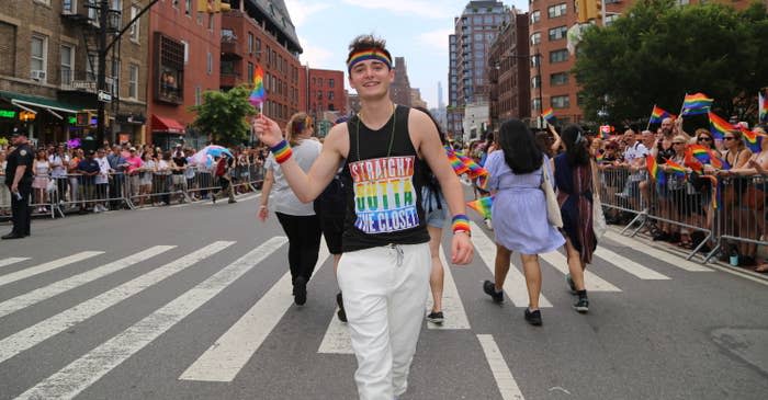 Noah Schnapp marching at Pride and wearing a "Straight Outta the Closet" sleeveless T-shirt