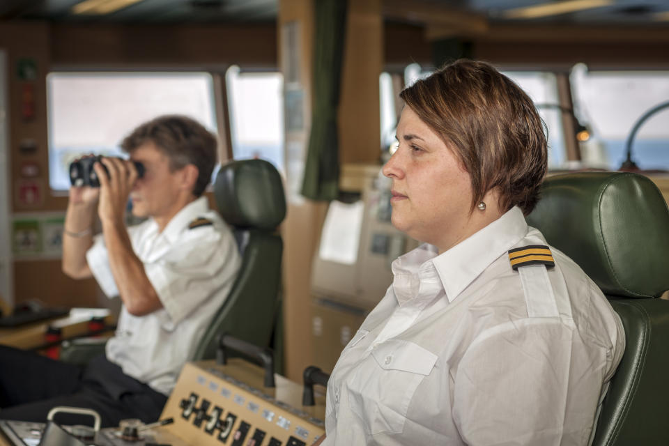 Two ship officers working, one observing through binoculars while the other monitors