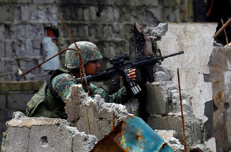 A government soldier from Philippine Marines 1st Brigade takes up a position as troops continue their assault on clearing operations against the pro-Islamic State militant group in Marawi city, southern Philippines, September 14, 2017. REUTERS/Marconi Navales