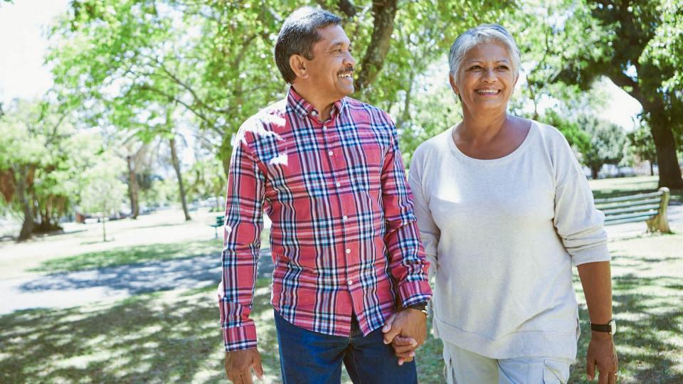 retired couple walking in the shade in a park