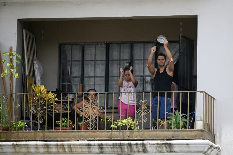 Opositores al gobierno del presidente venezolano Nicolás Maduro golpean cacerolas desde su balcón en un edificio en Caracas el 29 de julio de 2024, un día después de las elecciones tachadas de fraude por la oposición (Federico PARRA)