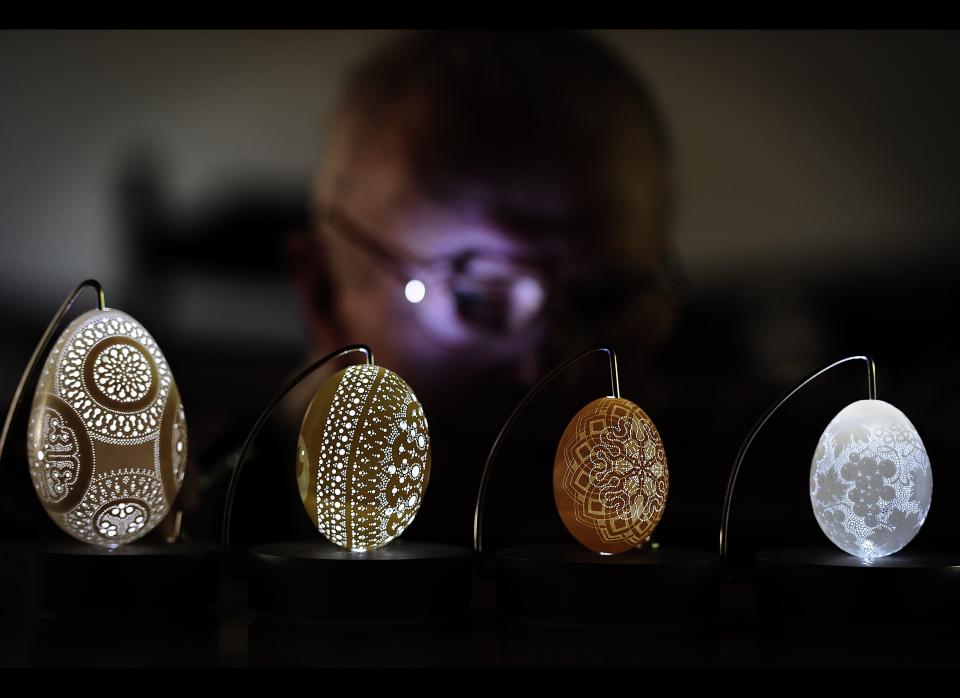 Franc Grom looks at his special Easter eggshells drilled with ornamental holes, in Stara Vrhnika, some 50 kilometers from Ljubljana on April 22, 2011. Grom, a 70-year old Slovenian craftsman has drilled holes in Easter eggshells for the last 18 years to make ornaments on them. He drills an approximate number of 2500 to 3500 holes to make a single special Easter eggshell for which he spends usually one week. Grom is the only artist making craftworks on eggshells by drilling this number of holes. AFP PHOTO/ HRVOJE POLAN 