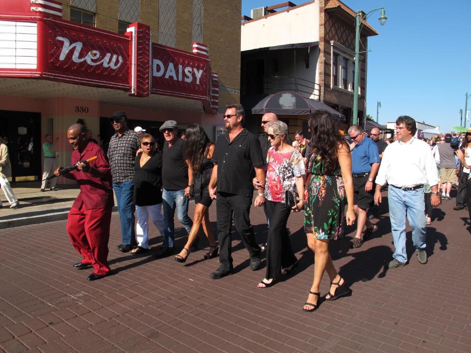 Friends of Donald "Duck" Dunn participate in a funeral parade down Memphis' Beale Street to honor the late soul bassist on Wednesday, May 23, 2012 in Memphis, Tenn. More than 100 fans walked and danced down the Memphis drag during the New Orleans-style parade to remember Dunn, who died May 13 at age 70 while on tour in Japan. (AP Photo/Adrian Sainz)