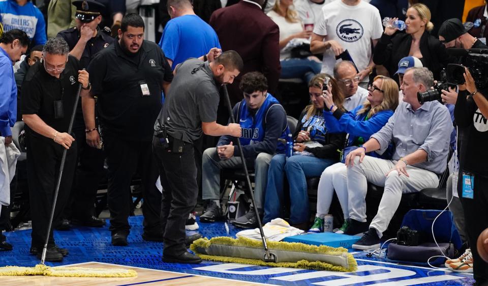 American Airlines Center employees mop up rain that was leaking from the roof during the second half of Game 4 of the NBA basketball playoffs Western Conference finals between the Dallas Mavericks and the Golden State Warriors, Tuesday, May 24, 2022, in Dallas. (AP Photo/Tony Gutierrez)