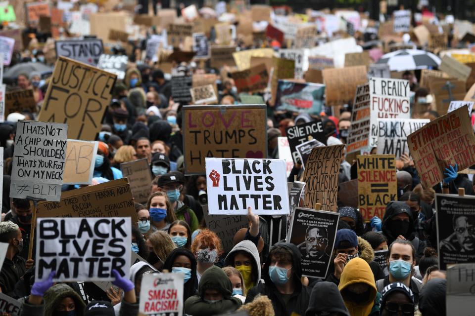 Protesters hold placards as they attend a demonstration in Parliament Square in central London on June 6, 2020, to show solidarity with the Black Lives Matter movement in the wake of the killing of George Floyd, an unarmed black man who died after a police officer knelt on his neck in Minneapolis. - Taking a knee, chanting and ignoring social distancing measures, outraged protesters from Sydney to London kicked off a weekend of global rallies Saturday against racism and police brutality. (Photo by DANIEL LEAL-OLIVAS / AFP) (Photo by DANIEL LEAL-OLIVAS/AFP via Getty Images)