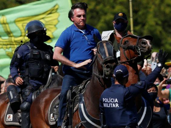 Jair Bolsonaro rides a horse during a demonstration by his supporters in Brasilia, 31 May (REUTERS)