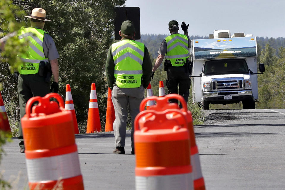 U.S. Park Rangers wave through the final visitor of the day before closing the entrance to the Grand Canyon for the day on May 15. The National Park Service is using a phased approach to increase access on a park-by-park basis during the COVID-19 pandemic. (Photo: ASSOCIATED PRESS/Matt York)