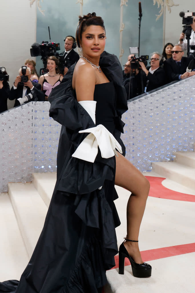 Priyanka Chopra in a layered gown with a bow, posing on the stairs at an event