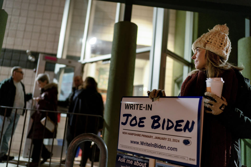 Ashley Marcoux stands outside a polling site with a campaign sign supporting President Joe Biden as a write-in candidate for the New Hampshire presidential primary in Manchester, N.H., Tuesday, Jan. 23, 2024. (AP Photo/David Goldman)