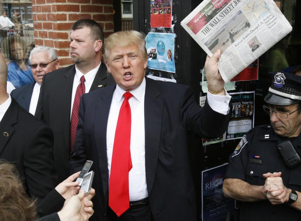 Donald Trump holds up a newspaper as he makes a reference to a story in it while walking through downtown Portsmouth, New Hampshire: Reuters