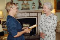 <p>La reina Isabel II en una reunión diplomática inviste a Dame Judi Dench con la Insignia de Compañera de Honor en el Palacio de Buckingham.</p>