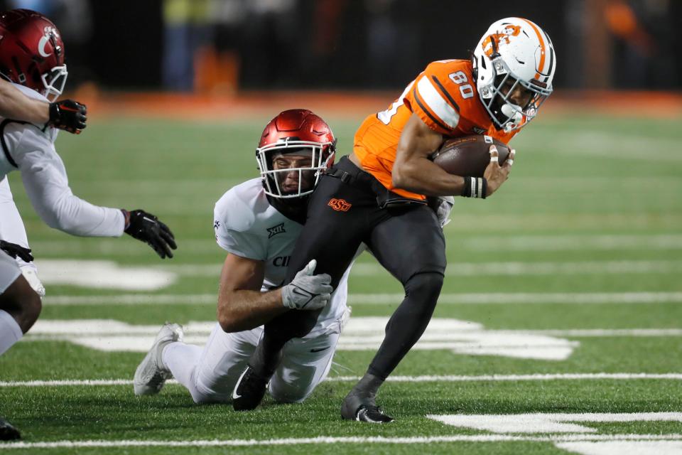 Oct 28, 2023; Stillwater, Oklahoma, USA; Oklahoma State Cowboys wide receiver Brennan Presley (80) is brought down by Cincinnati Bearcats linebacker Jack Dingle (49) during a college football game between Oklahoma State and Cincinnati at Boone Pickens Stadium. Mandatory Credit: Bryan Terry-USA TODAY Sports