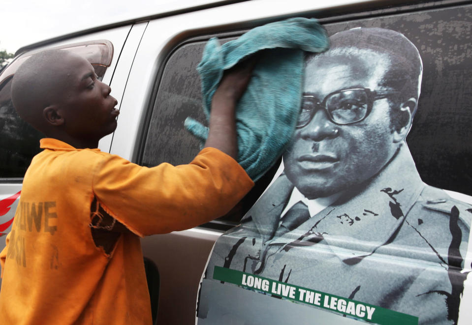 <p>Youth washes a minibus adorned with picture of President Robert Mugabe at a bus terminus in Harare, Zimbabwe, Nov. 15, 2017. (Photo: Philimon Bulawayo/Reuters) </p>