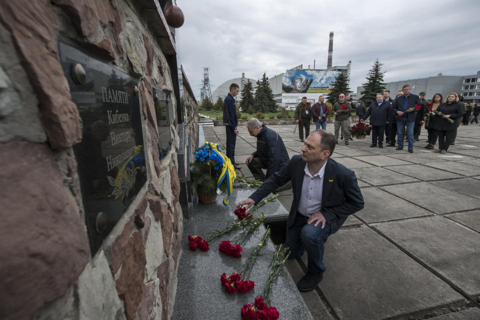 Chernobyl's nuclear power plant workers lay flowers at a monument to the victims of the Chernobyl tragedy during a memorial ceremony in Chernobyl, Ukraine, Wednesday, April 26, 2023. Ukrainian President Volodymyr Zelenskyy on Wednesday used the 37th anniversary of the world’s worst nuclear disaster to repeat his warnings about the potential threat of a new atomic catastrophe in Ukraine amid his country's war with Russia. (AP Photo/Wladyslaw Musiienko)