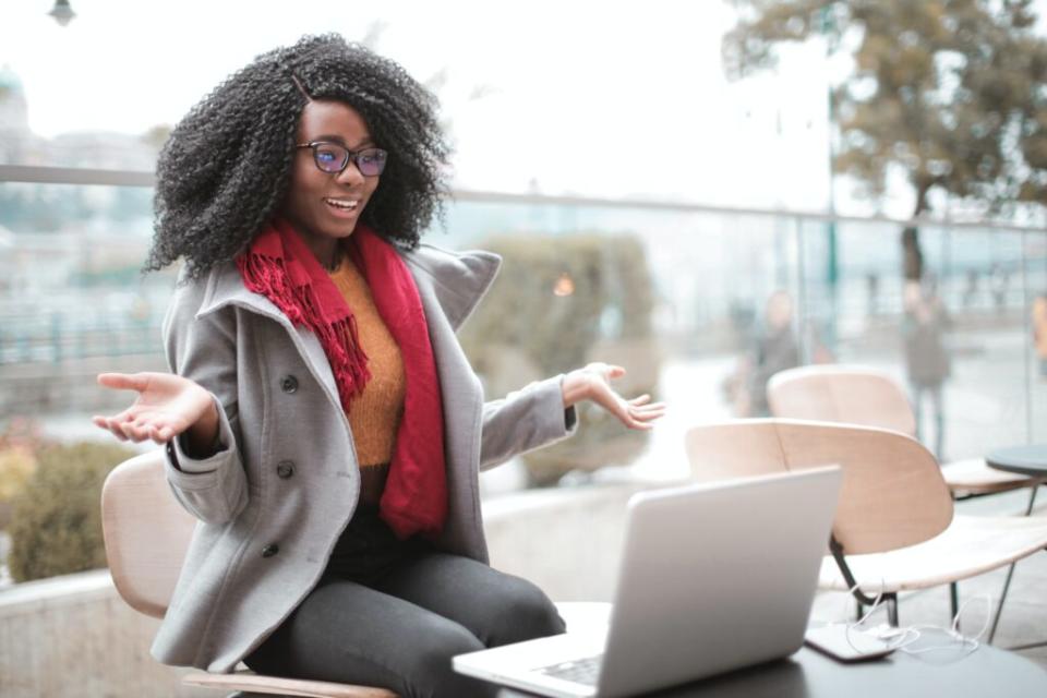 A cheerful Black woman smiling during a video call.