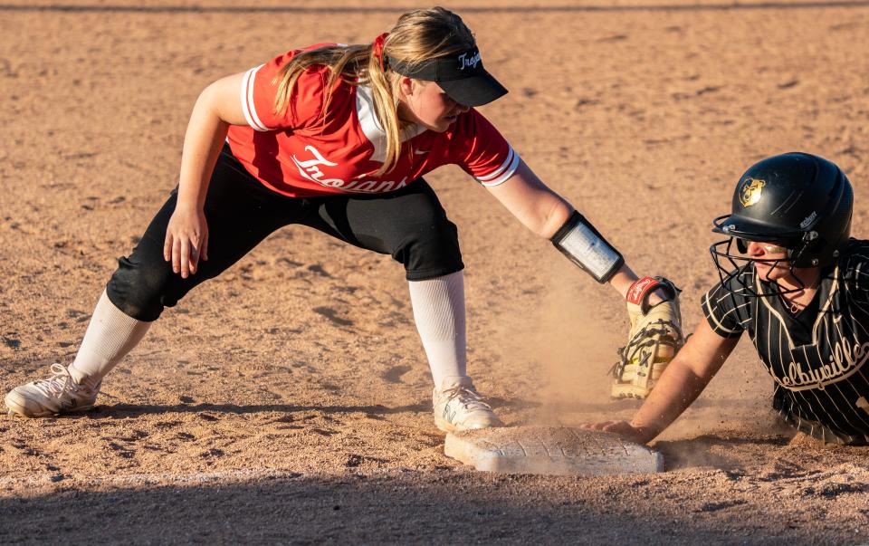 Shelbyville junior Cheyenne Eads dives back into first during Wednesday's evening game at Shelbyville High School. The Shelbyville Golden Bears took on the Center Grove Trojans in a tough high school softball matchup Wednesday, April 12, 2023, in Shelbyville, Ind. with the Trojans winning 3-1 over the Golden Bears.