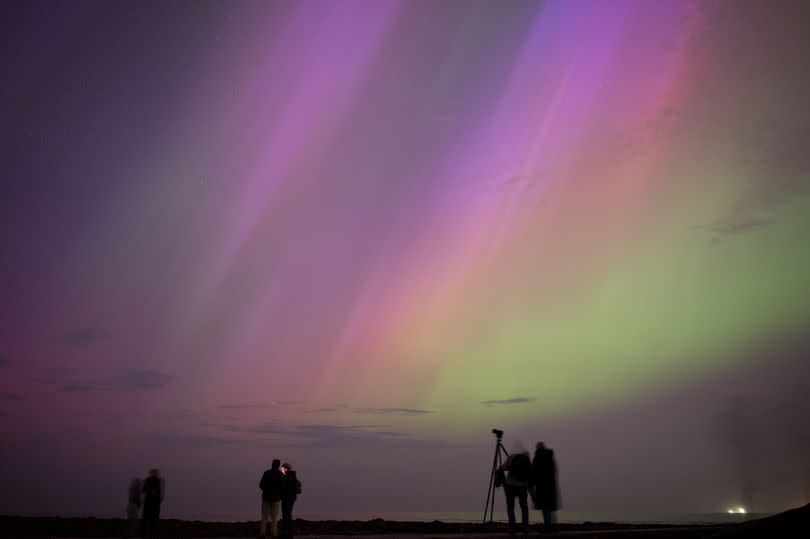 People visit St Mary's lighthouse in Whitley Bay to see the aurora borealis, commonly known as the northern lights, on May 10, 2024 in Whitley Bay, England. The UK met office said a strong solar storm may allow northern parts of the UK the chance to see displays of aurora.