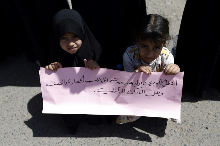 Yemeni girls hold a placard reading "The education sector is facing difficulties due to the siege and shelling" during a demonstration in Sanaa on September 17, 2017