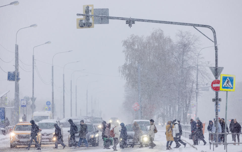 La gente cruza la calle durante una nevada en el primer día nevado de la temporada, en Moscú, Rusia, el 27 de octubre de 2023. REUTERS/Maxim Shemetov