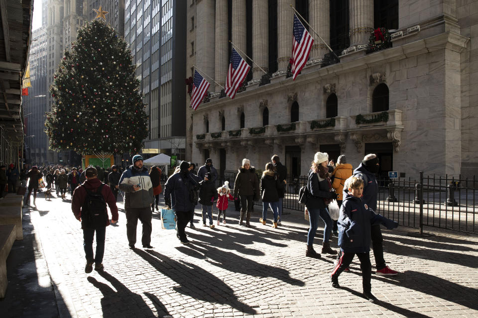 People walk by the New York Stock Exchange, Tuesday, Dec. 3, 2019. Stocks fell broadly Tuesday after President Donald Trump cast doubt over the potential for a trade deal with China this year and threatened to impose tariffs on French goods. (AP Photo/Mark Lennihan)