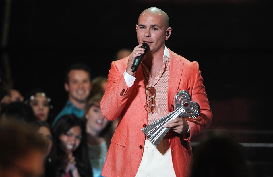 Pitbull presents the award for hip hop/R&B song of the year at the iHeartRadio Music Awards at the Shrine Auditorium on Thursday, May 1, 2014, in Los Angeles. (Photo by Chris Pizzello/Invision/AP)