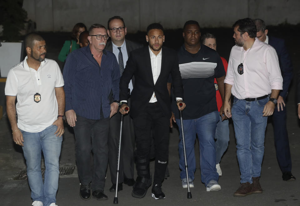 Using crutches because of an injured right ankle, Brazil's soccer player Neymar leaves a police station where he answered questions about rape allegations against him in Sao Paulo, Brazil, Thursday, June 13, 2019. Neymar denies any wrongdoing. (AP Photo/Andre Penner)