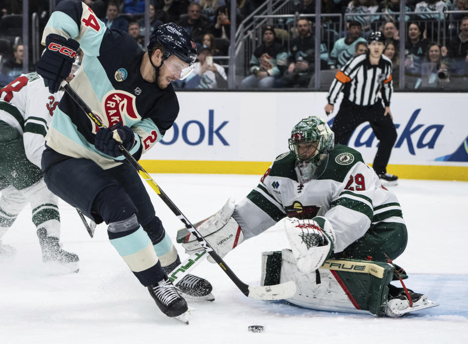 Seattle Kraken defenseman Jamie Oleksiak, left, shoots against Minnesota Wild goalie Marc-Andre Fleury during the second period of an NHL hockey game Saturday, Feb. 24, 2024, in Seattle. (AP Photo/Stephen Brashear)