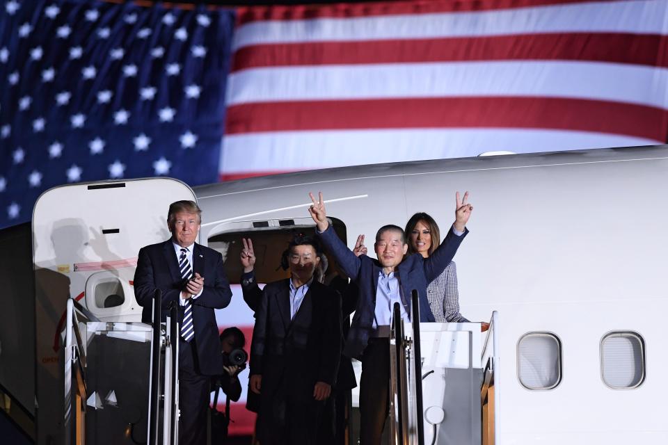 President Donald Trump applauds as Kim Dong-chul gestures upon his return with Kim Hak-song and Tony Kim after they were freed by North Korea, at Joint Base Andrews in Maryland on May 10, 2018.